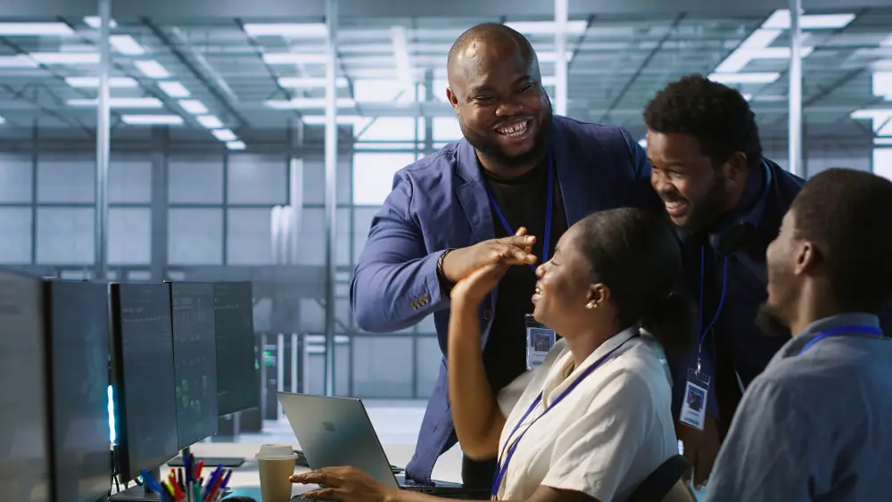 Healthcare staff smiling together at a workstation